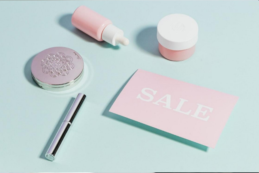 A group of cosmetics placed next to a sale sign