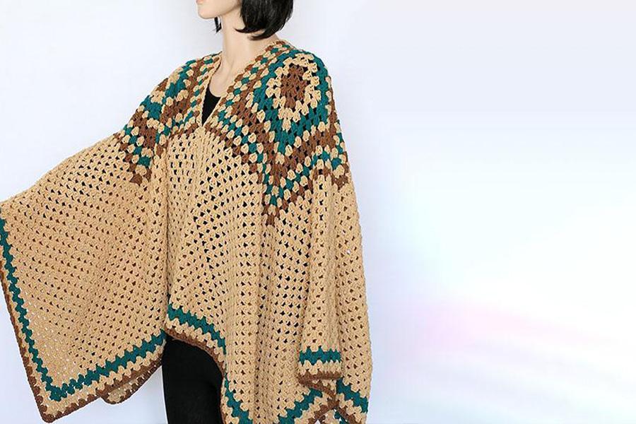 A woman in a camel crocheted poncho
