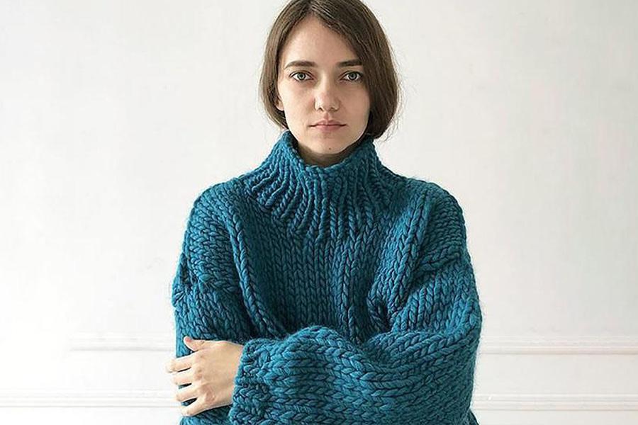 A woman in a deep blue crew neck sweater