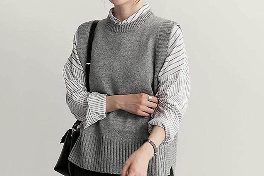 A woman in a gray knitted sweater vest