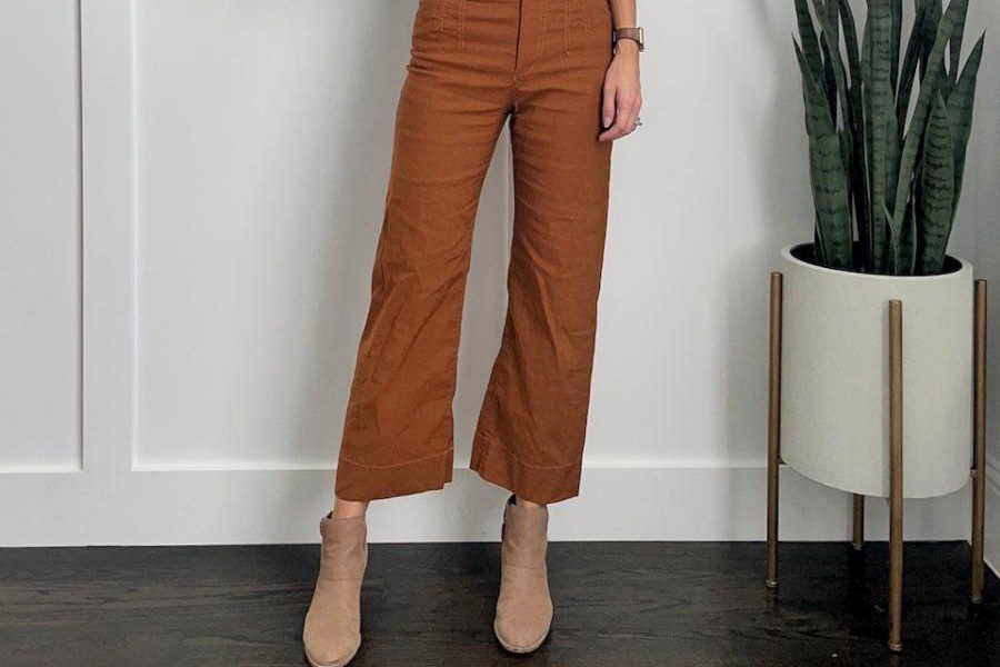 A woman wearing brown colored wide leg trousers