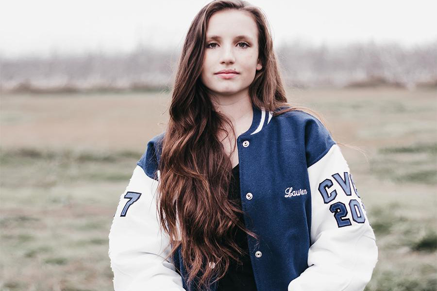 A young lady in blue and white letterman bomber jacket