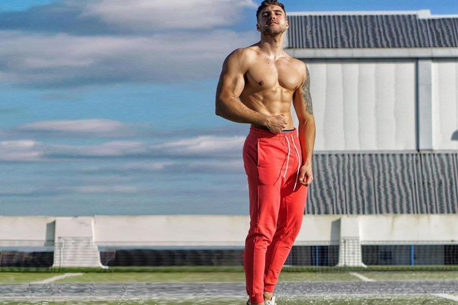 Athletic man rocking a red sweatpants on a field