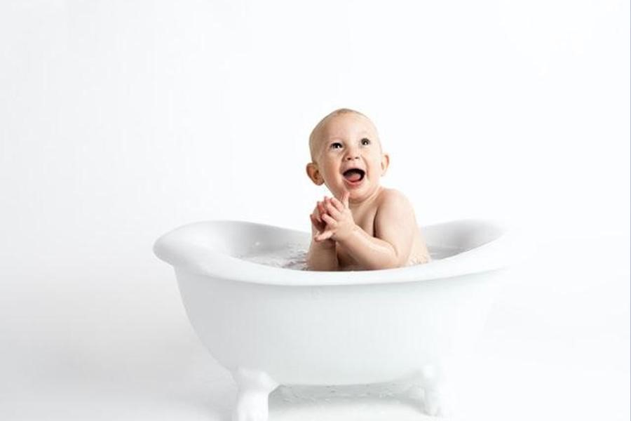 Baby taking a bath in small bathtub