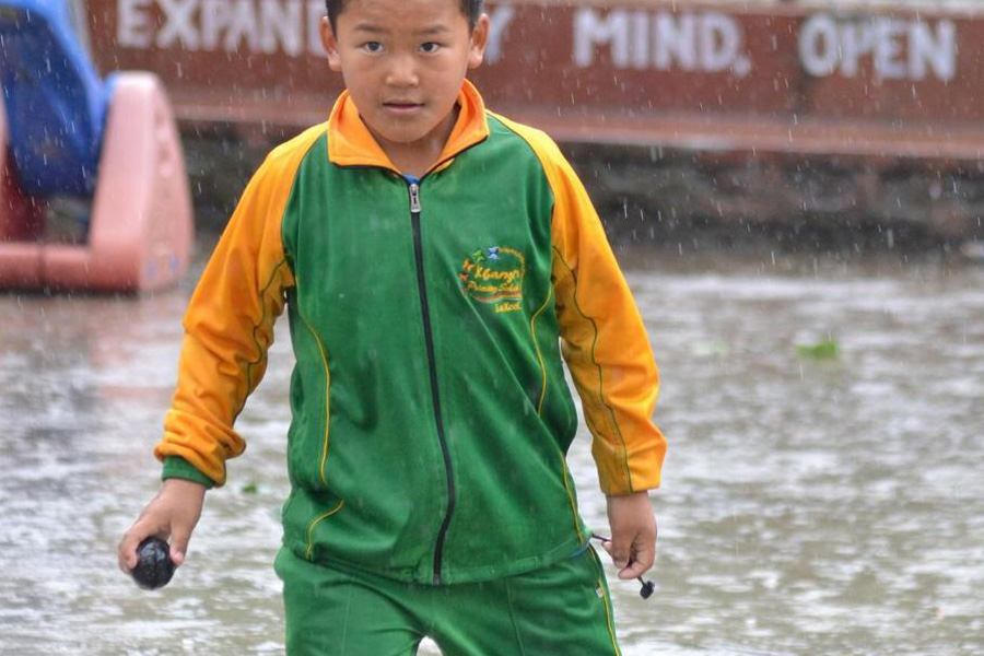 Boy in a matching green and yellow tracksuit