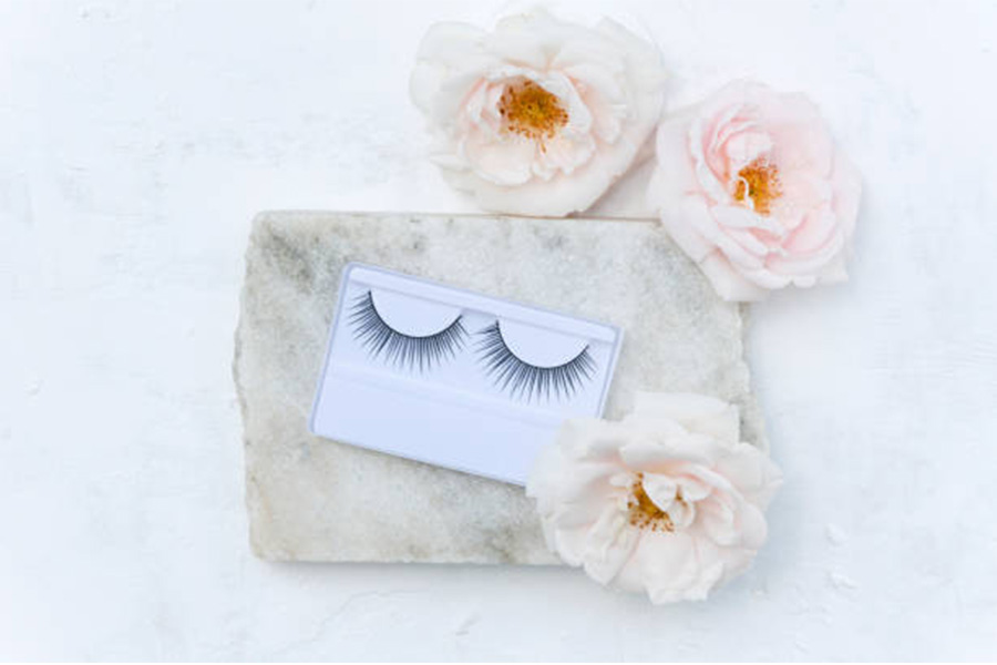 False eyelashes in a white box positioned on a stone