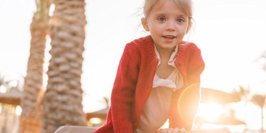 Girl wearing a red cardigan under the sunset