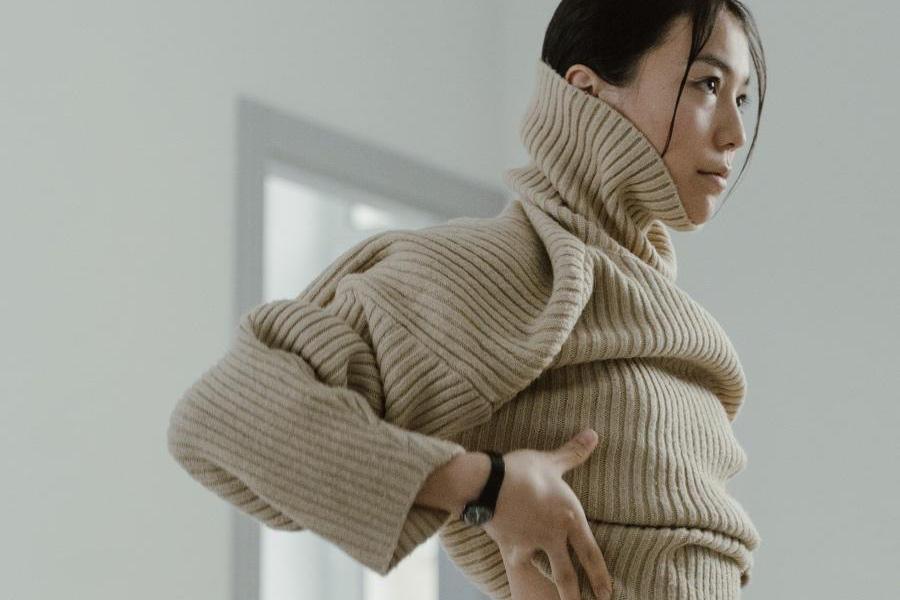 Lady wearing a knitted cream rollneck sweater