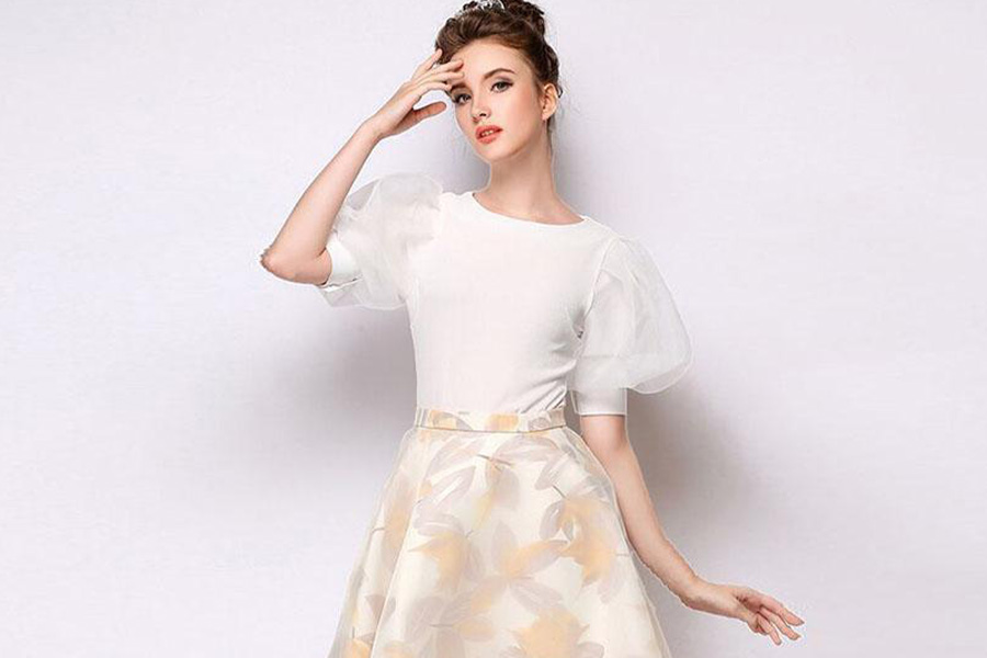 Lady wearing white puffy-sleeved blouse with floral-patterned skirt