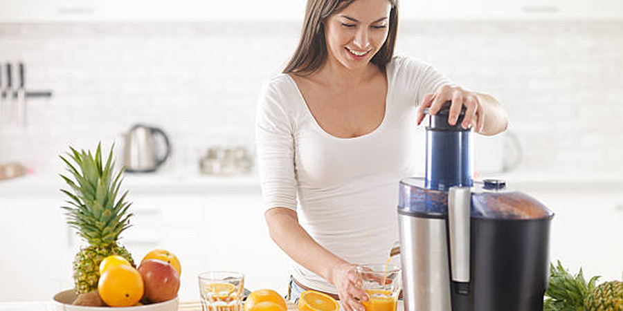 Large fruit juicer being used with fresh oranges