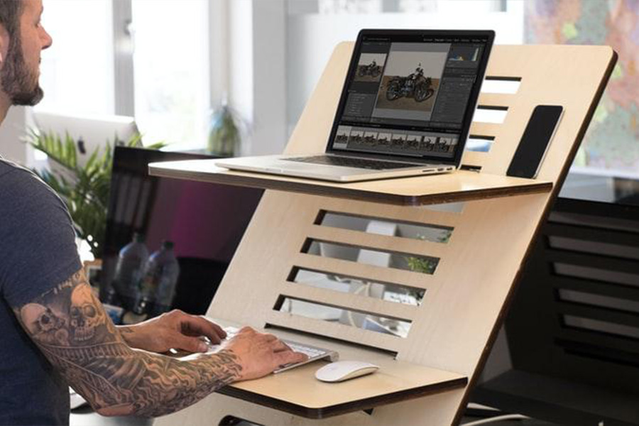 Man working on a standing desk laptop stand