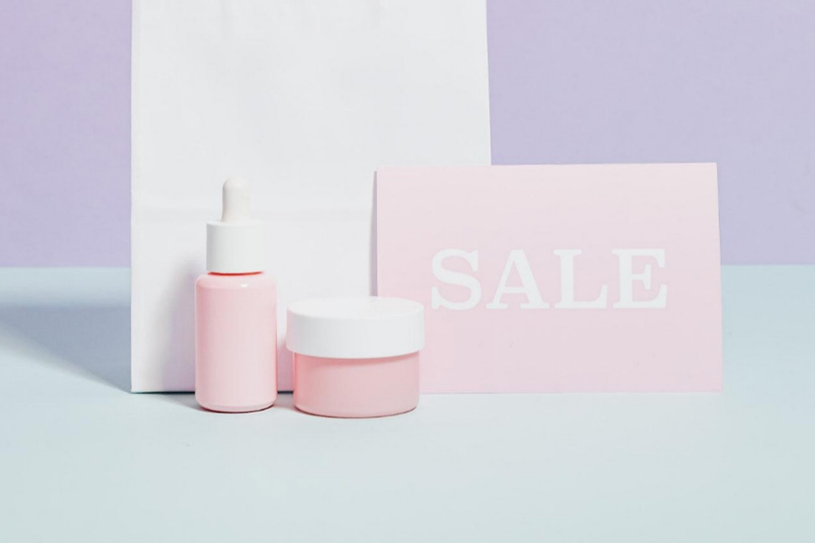 Pink color cosmetics placed next to a sale sign