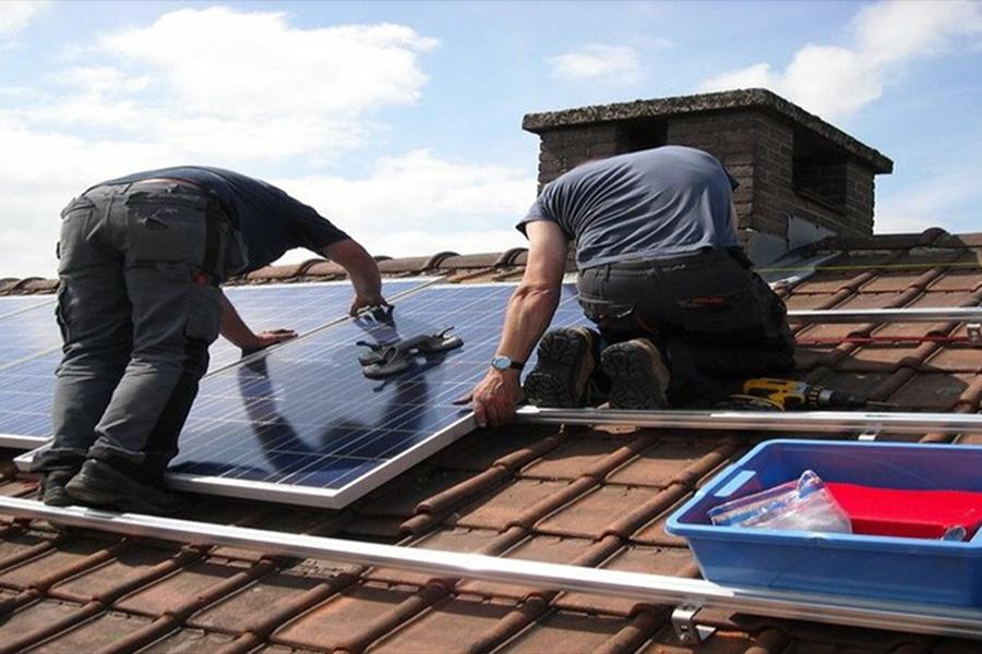 Technicians installing solar panels on a roof