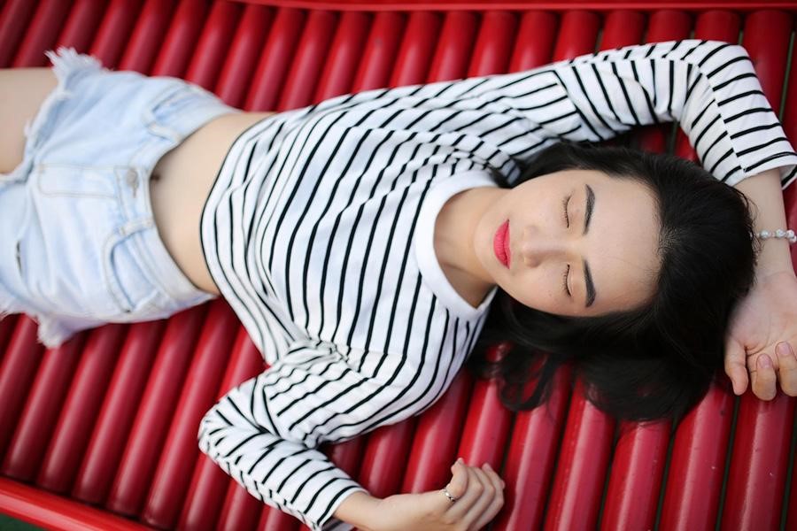 Teen girl lying down with striped top and shorts