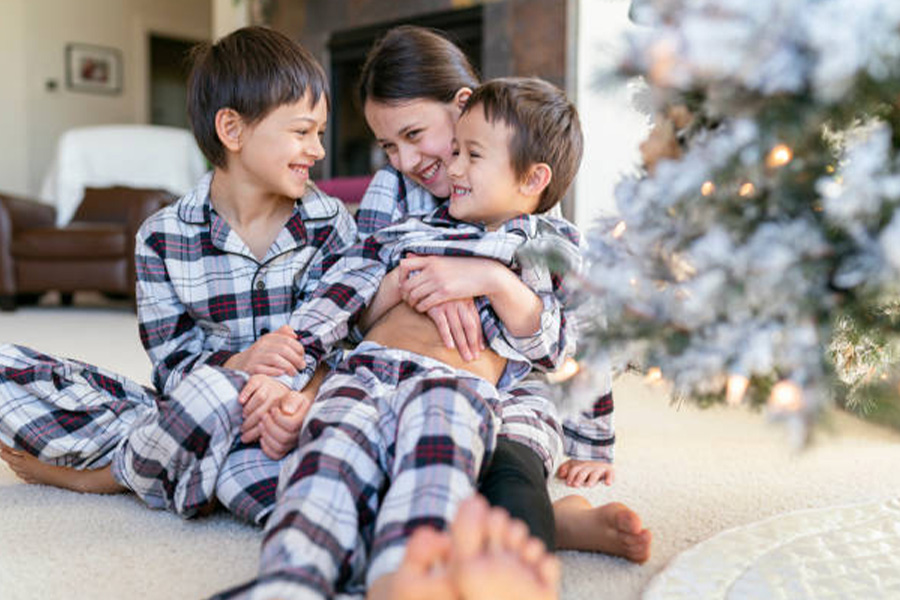 Three children in matching family pajama set at Christmas