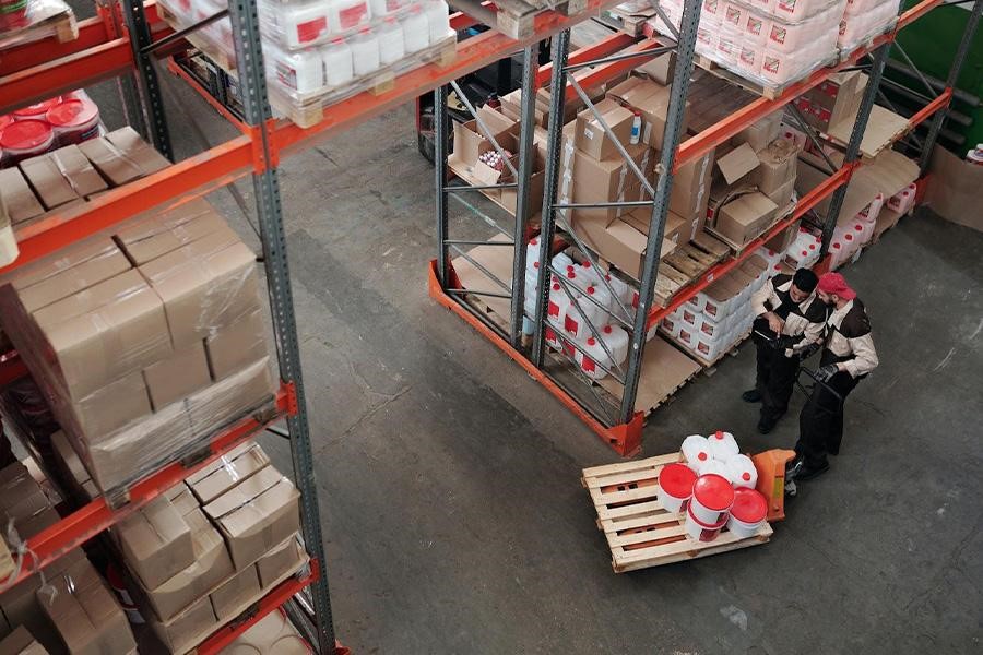 Two workers in a warehouse with packaged goods