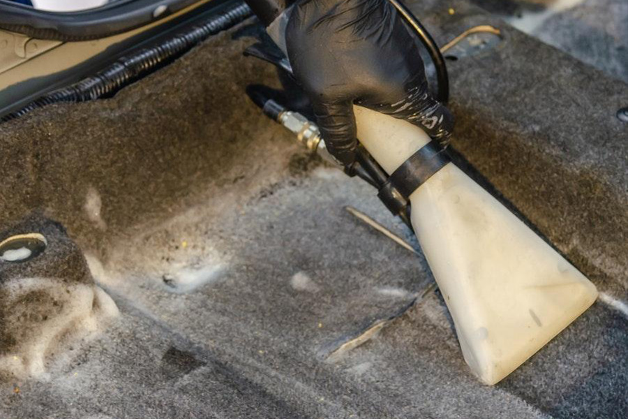Vacuuming a dirty car mat