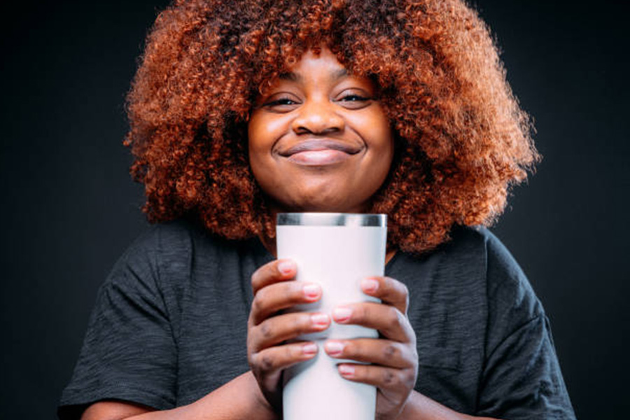 Woman holding a white stainless steel tumbler in hands