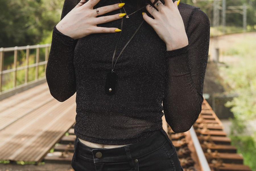 Woman posing in a sheer top and black denim pants