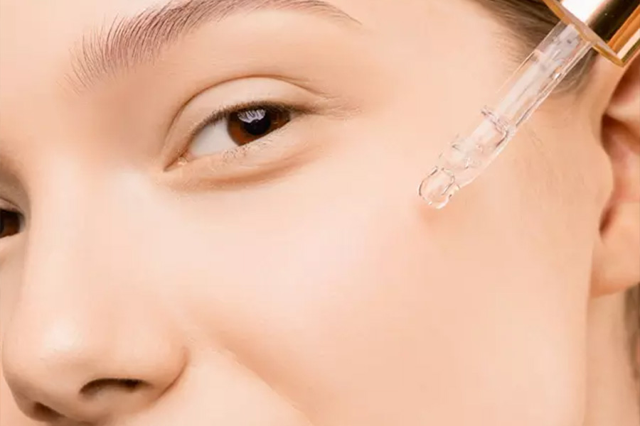 Woman putting a moisturizing serum on her face skin