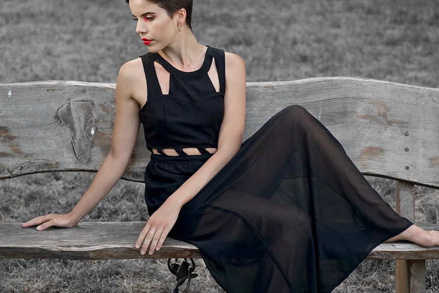 Woman rocking a black dress, sitting on a bench