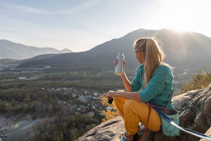 Woman sitting at a viewpoint with a white water bottle
