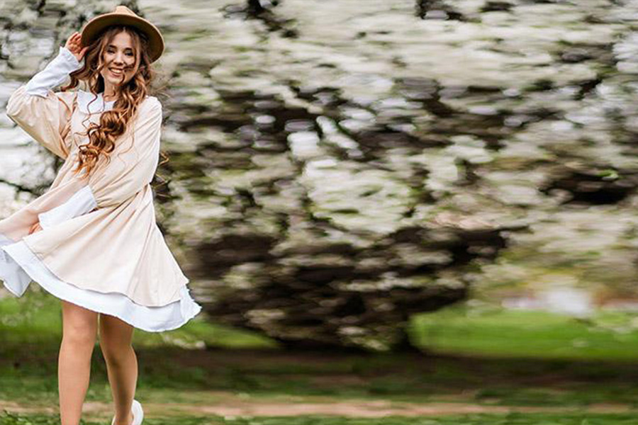 Woman wearing beige short and flare dress in the woods