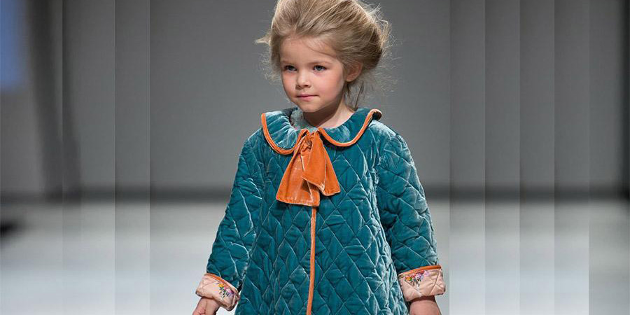 Young beautiful female child wearing a green quilted dress