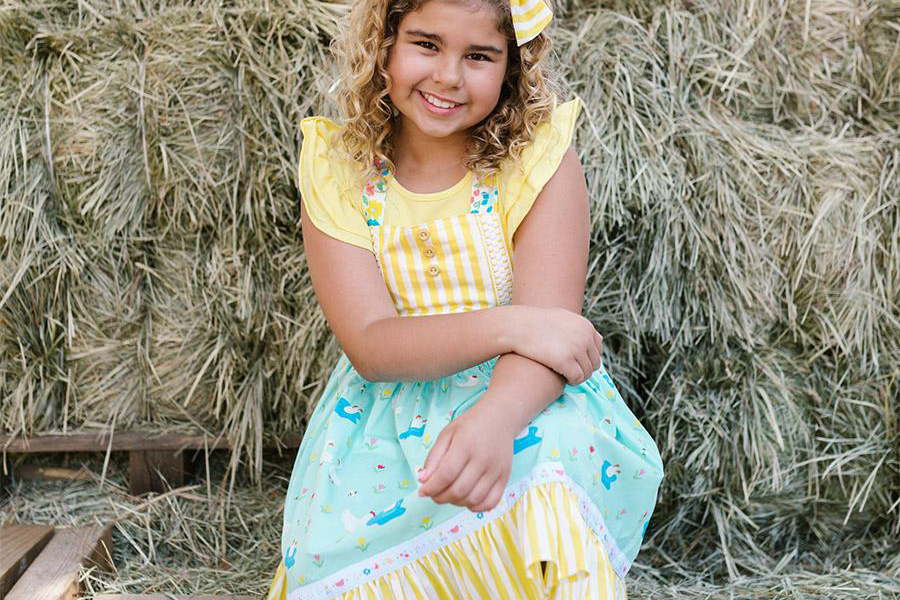 Young girl rocking a yellow and blue plush plaid dress