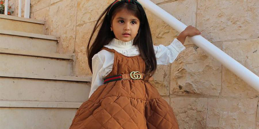 Young girl wearing a light brown quilted dress