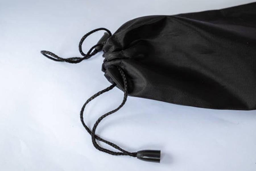 A black satin drawstring bag against a white backdrop