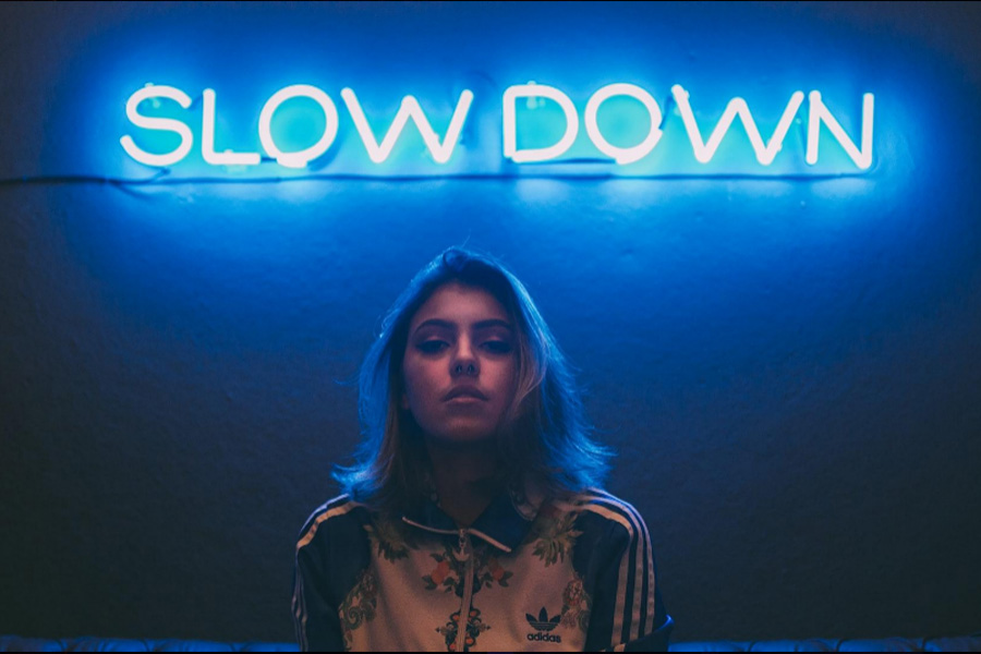A neon sign that says slow down
