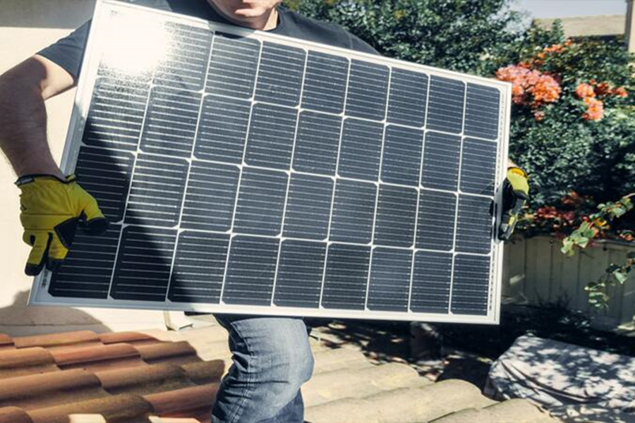A technician carrying an off-grid solar panel