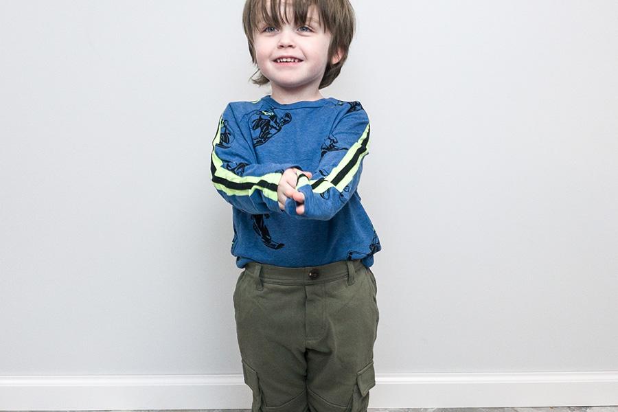 Boy posing in a blue top and army green cargo pants