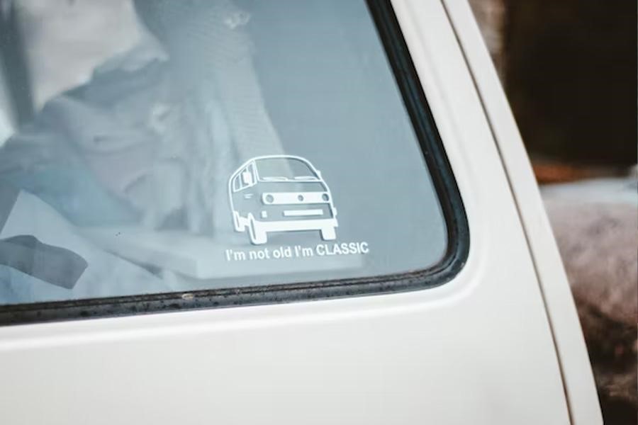 Car window with sticker of old van in white