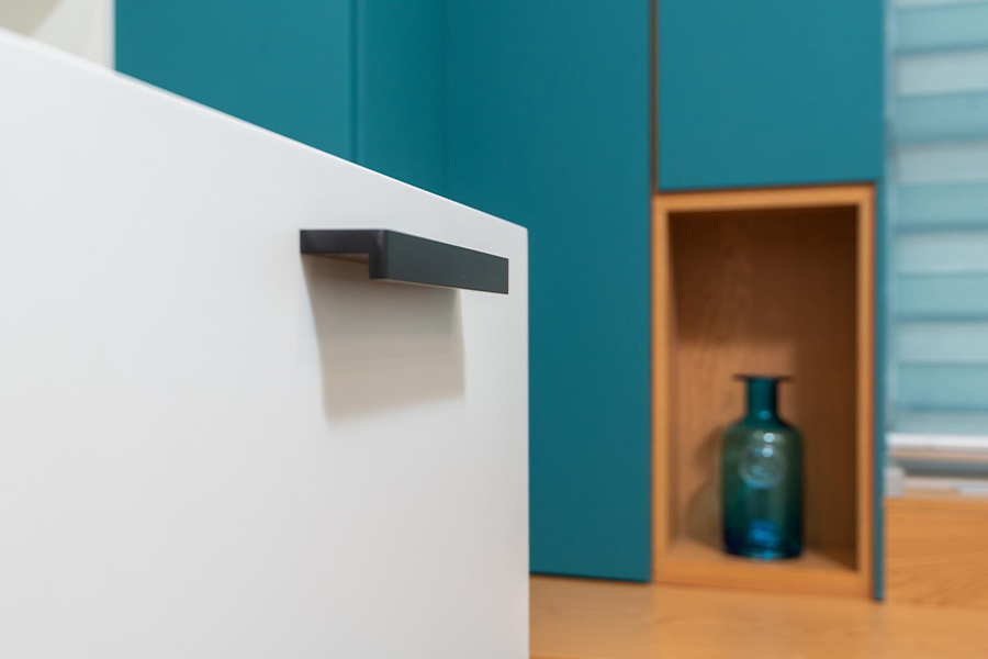 A contemporary cupboard with teal backdrop