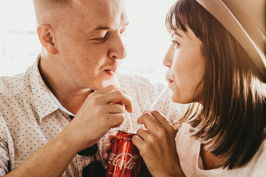 Couple sharing an intimate moment over a Coca-Cola drink