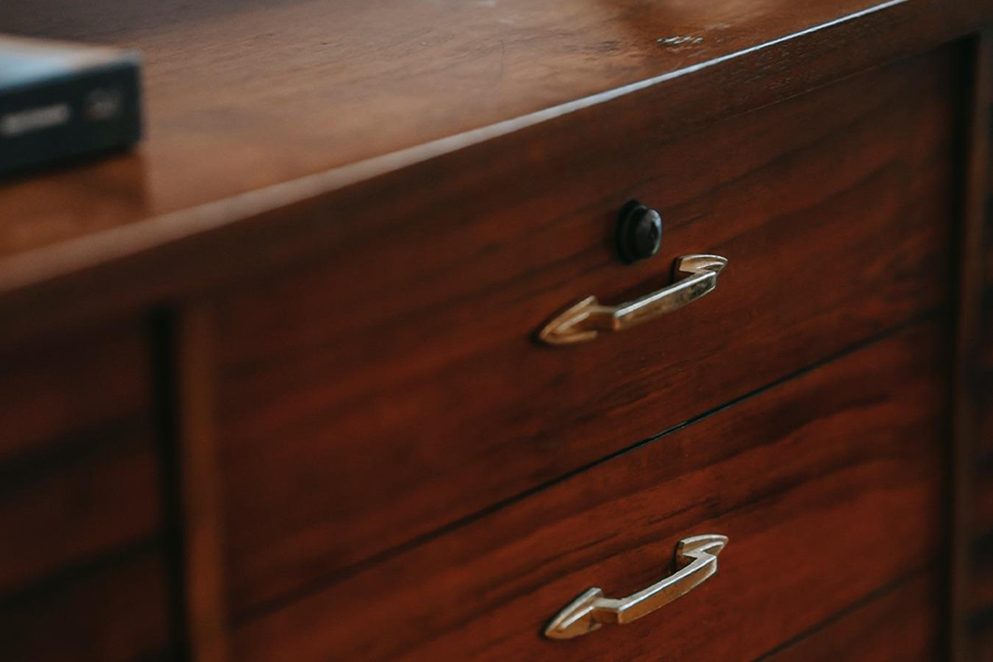 A dark traditional cupboard with handles