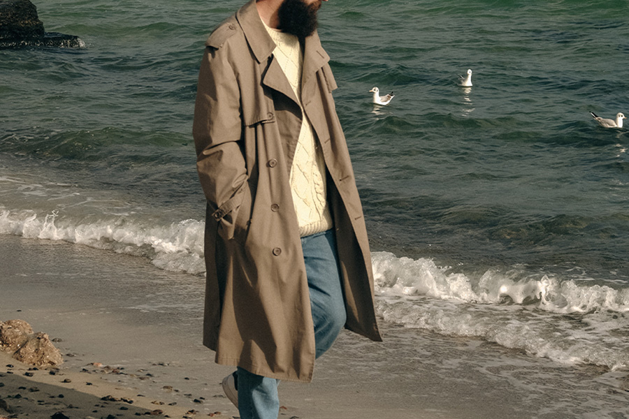 Man walking on a beach with duster jacket