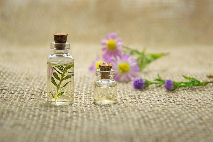 Natural fragrance bottle next to flowers