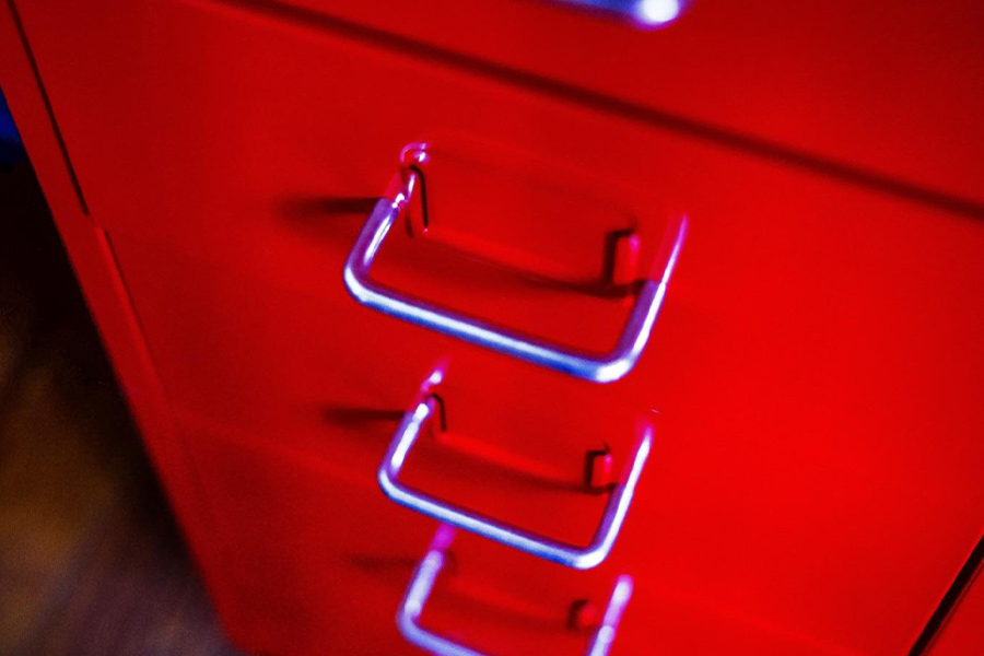 A red filing cabinet with contemporary steel handles