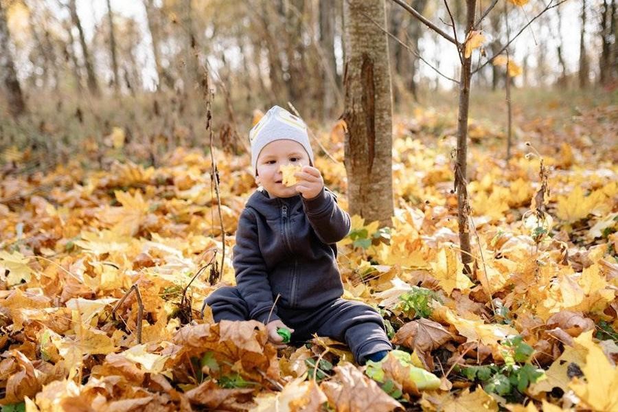 Toddler wearing a black jacket in the woods
