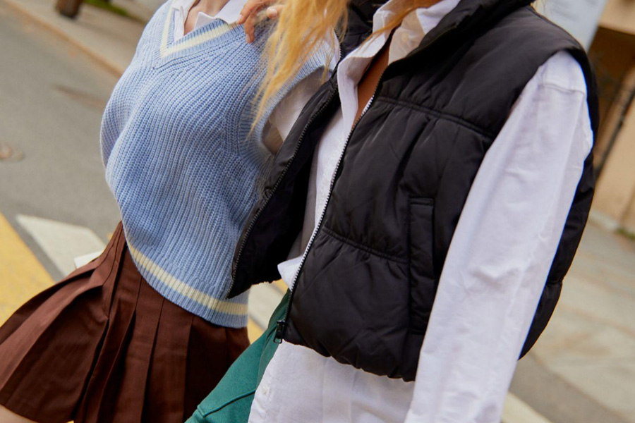 Two girls wearing a blue and black vest