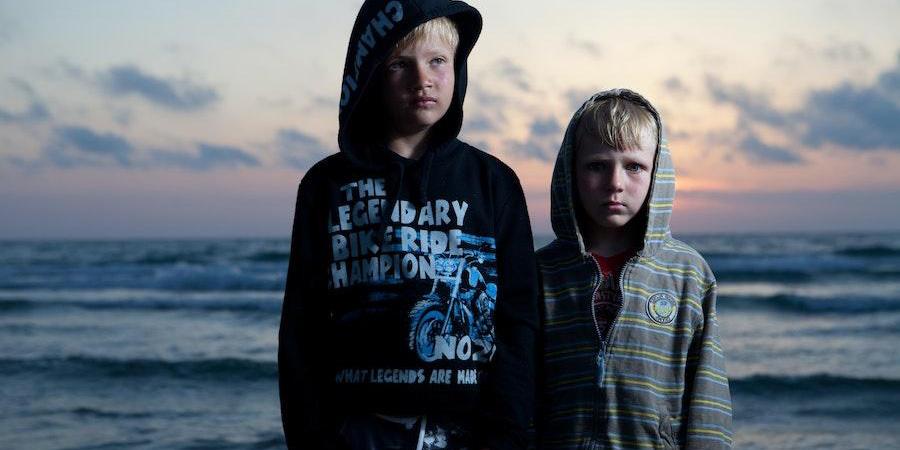 Two young boys rocking hoodie tops at the beach