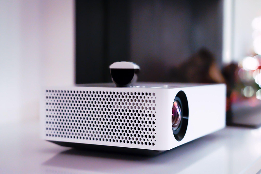 White projector with a remote on top