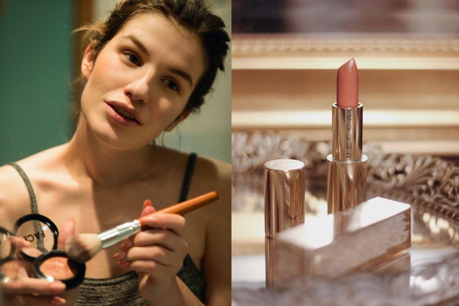 A woman applying makeup; a nude lipstick