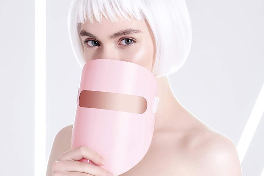 woman holding LED light therapy mask