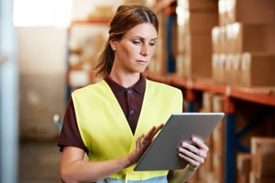 Woman in warehouse checking inventory