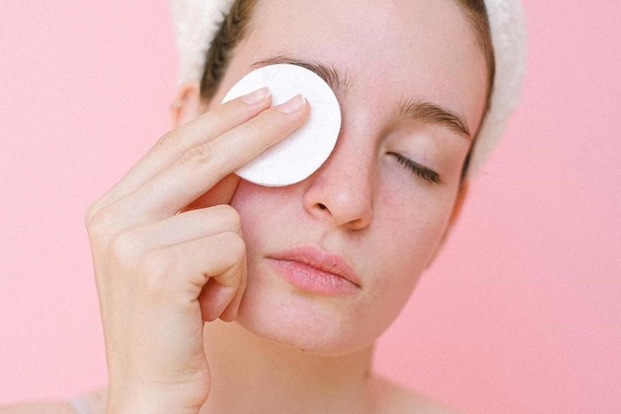 Woman removing makeup with reusable cotton pad