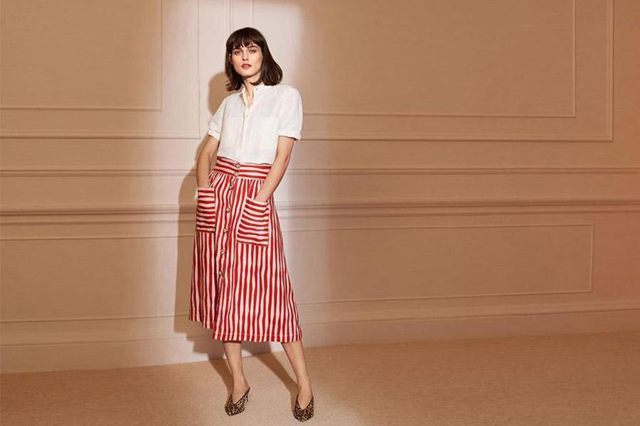 Woman wearing a white top and red-striped A-line skirt